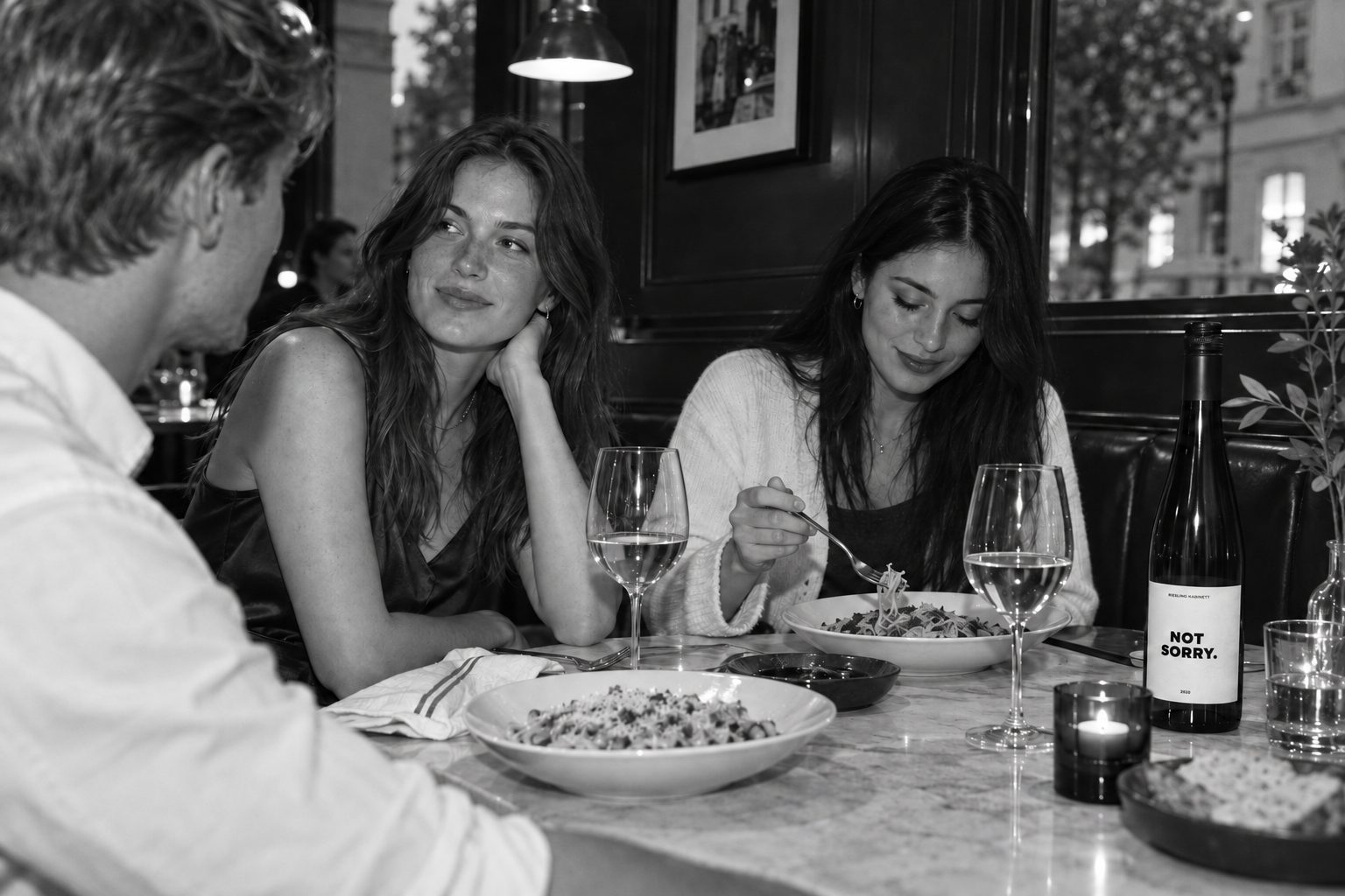 Restauranttisch am Abend, Weißweingläser und die Flasche